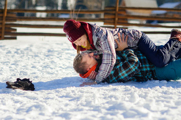 Young couple cheerfully flounders in snow