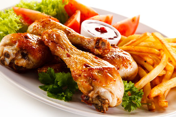 Grilled chicken legs with chips and vegetables
