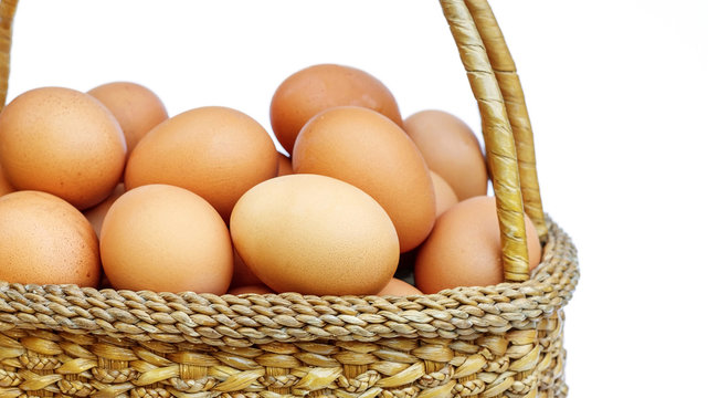 chicken eggs in a basket on white background.