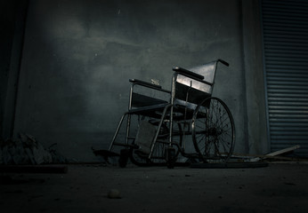 old wheelchair was forsaken in old room. lonely and scary concept. halloween theme