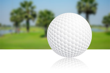 Golf ball on white surface and fairway in background