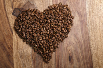 heart from coffee beans on wood background, old rustic table