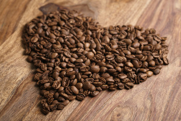 heart from coffee beans on wood background, old rustic table