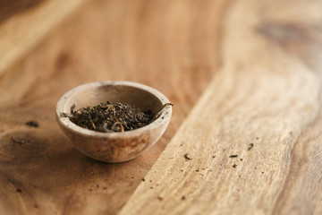 golden orchid tea in small bowl on wood table, copy space