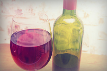 Bottle of red wine with glass ready to pour