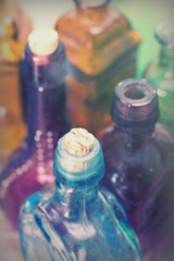 Coloured glass bottles on a rustic background