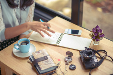 Coffee table with notebook, camera, diary, compass, and mobile phone