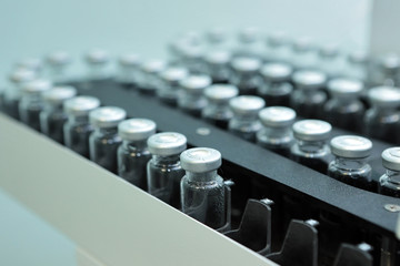 Sterile capsules for injection. Bottles on the bottling line of the pharmaceutical plant. Machine...