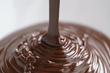 premium dark chocolate pour in bowl, shallow focus