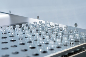 Sterile capsules for injection. Bottles on the bottling line of the pharmaceutical plant. Machine...