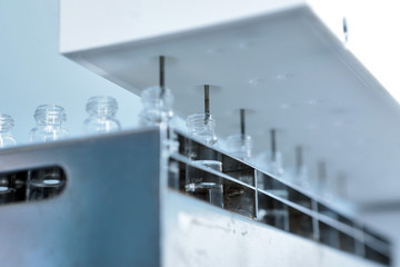 Sterile capsules for injection. Bottles on the bottling line of the pharmaceutical plant. Machine...