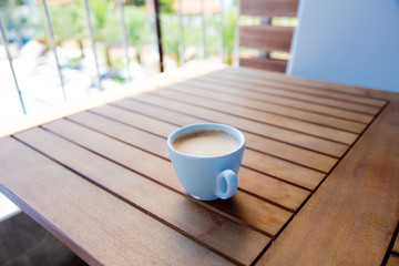 photo of beautiful blue cup of delicious coffee on the wonderful brown wooden table