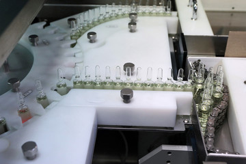 Sterile capsules for injection. Bottles on the bottling line of the pharmaceutical plant. Machine...