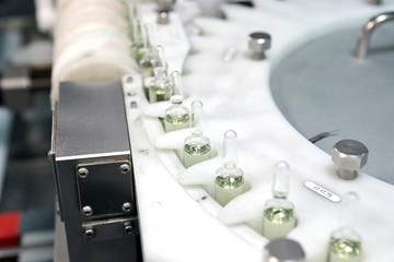 Sterile capsules for injection. Bottles on the bottling line of the pharmaceutical plant. Machine...