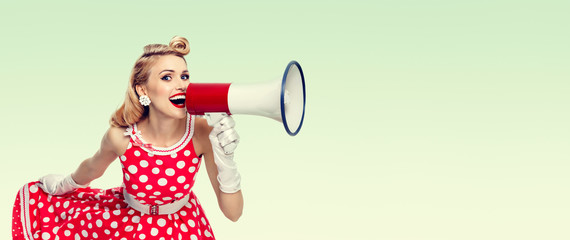 happy woman holding megaphone, dressed in pin-up style red dress
