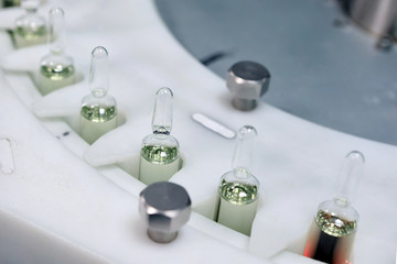 Sterile capsules for injection. Bottles on the bottling line of the pharmaceutical plant. Machine...
