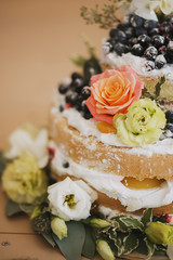 a beautiful cake decorated with flowers blueberry greens closeup