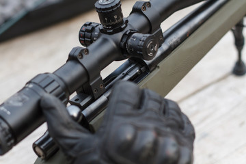 A man shoots a rifle. Rifle shooting with optical sight outdoors by man.