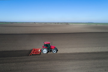 Tractor harrowing soil in spring