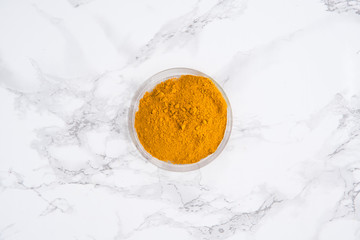 Top view of a turmeric powder in a bowl