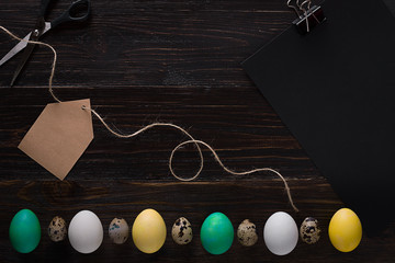 Greeting card with paschal eggs on rustic, wood table