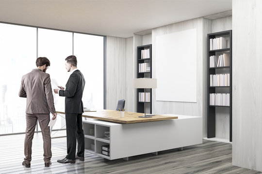 Two colleagues in a CEO office with gray walls