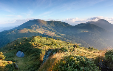 Green lawn with the pathway high on the mountains.