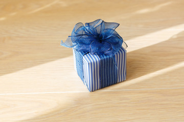 Gift box with a blue bow on a beige background