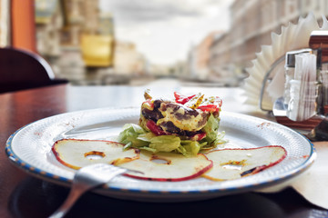 Hot salad with an apple on a white plate