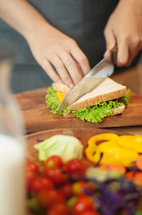 Woman cooking sandwich on wooden pan.