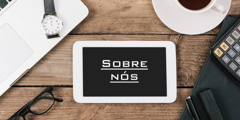 Sobre nós, Portuguese text for About Us on screen of tablet computer at office desk