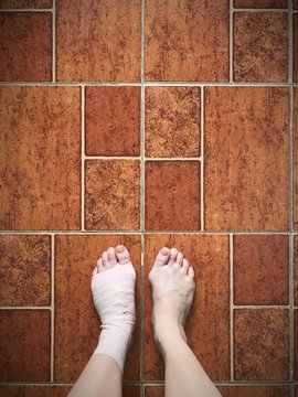 feet with bandages on brown floor