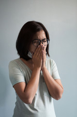 Illness, disease, cold  concepts.  Asian glasses woman has a cold and coughing. Girl with medical mask.