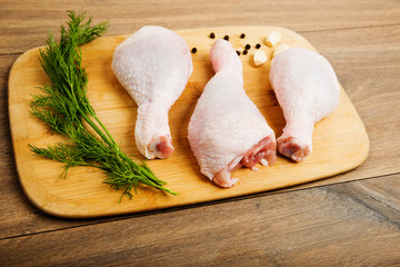 raw chicken legs on wooden board