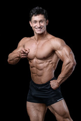 Fototapeta na wymiar Handsome caucasian muscular man on diet point fingers in gym..