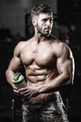 Fototapeta na wymiar Muscular Man Resting After Exercise And Drinking From Shaker