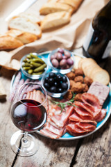 Red wine with charcuterie assortment on the background