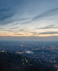 View from the hill on a city in the valley at sunset