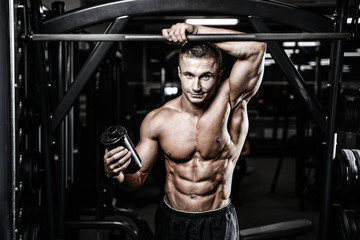 Fototapeta na wymiar Muscular Man Resting After Exercise And Drinking From Shaker