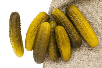 Pickled cucumbers on white isolated background with gray cloth texture