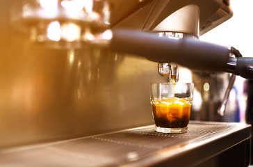 Espresso being prepared from coffee machine. 
