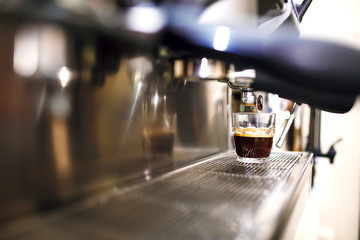 Espresso being prepared from coffee machine. 
