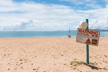 Warning sign of crocodile sighting on The Strand beach in Townsville, Australia