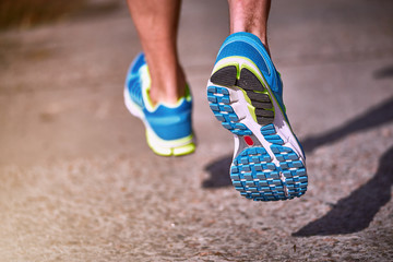 Foot closeup athlete running in sneakers outdoors.