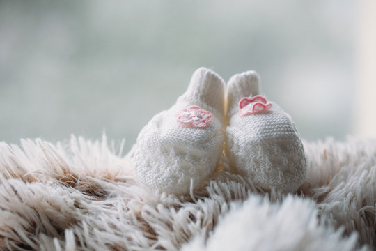 Knitted baby girl slippers. Newborn concept