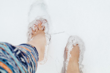 Girl barefoot on snow in winter. Quenching tempering harding health concept.
