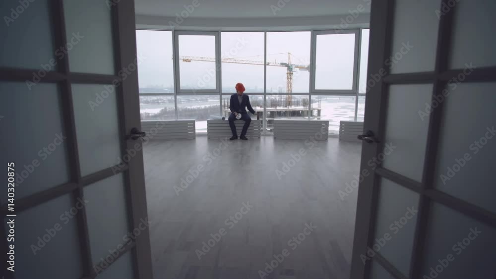 Poster civil engineer working with documents looking on architectural plan. man wearing in elegant suit on 