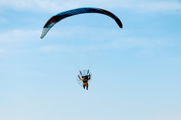 adventure man active extreme sport pilot flying in sky with paramotor engine glider parachute