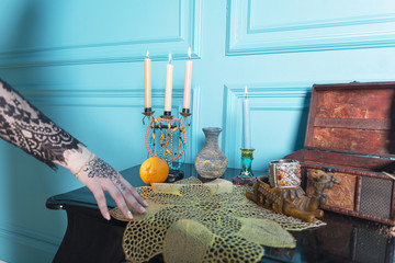 Chest, candles and a bottle on the table.