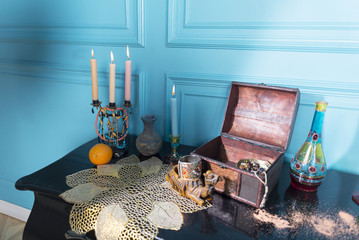 Chest, candles and a bottle on the stele.